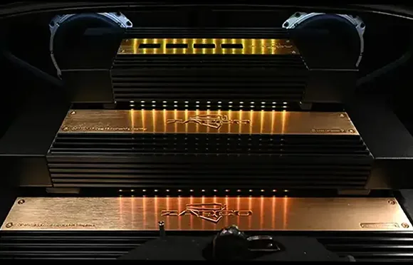 A custom car audio boot installation with three Zeroflex amplifiers and two speakers with subtle yellow and white LED lights.